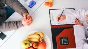 Médico nutrólogo em consulta orientando um paciente no consultório