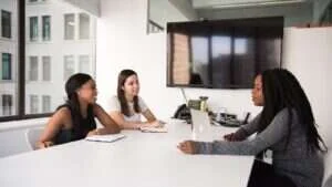 Profissionais de recursos humanos conversando durante entrevista em sala de reunião