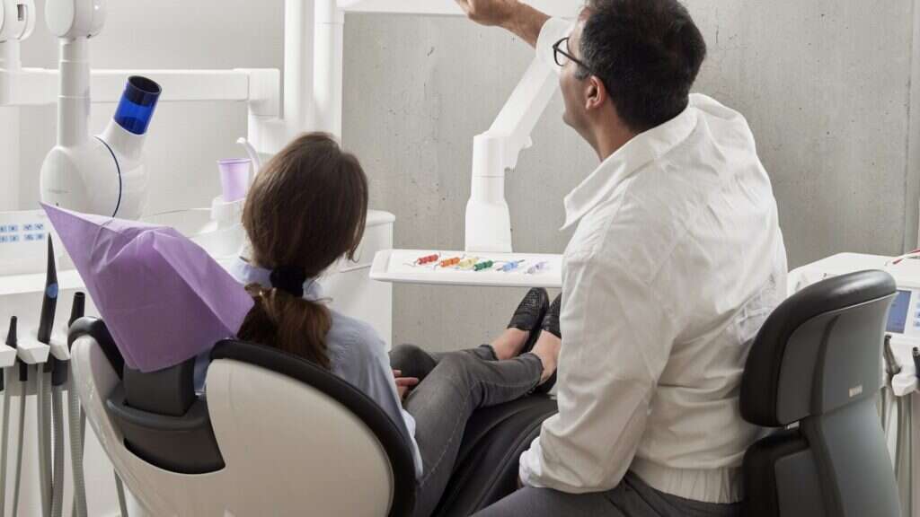 Dentista apresentando o plano de tratamento a um paciente no consultório