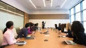 Executivos reunidos em sala de reunião analisando apresentação de resultados de marketing